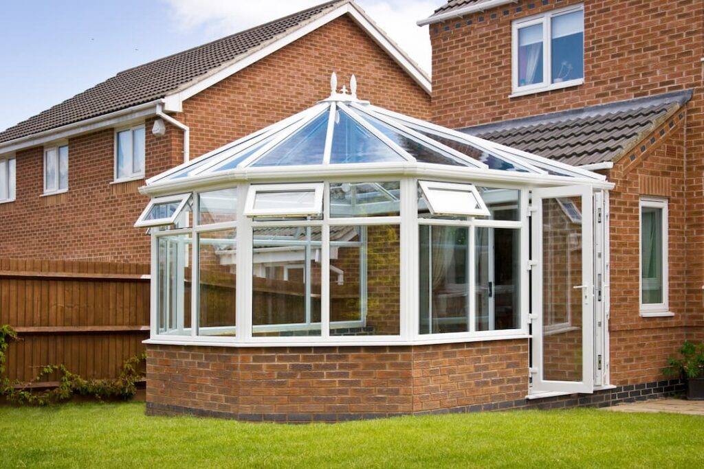 Glass conservatory attached to red brick house