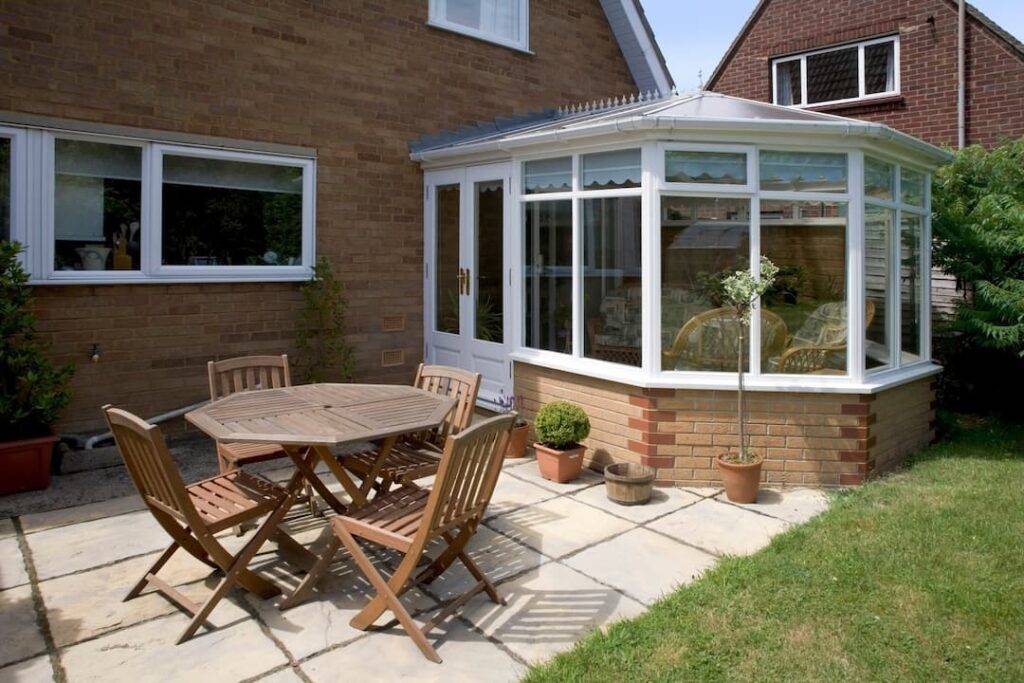 Glass conservatory attached to red brick house